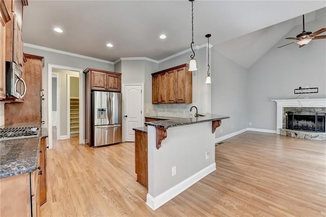 5195 Stefan Ridge Way, Buford, GA 30519 - kitchen with a peninsula, a kitchen breakfast bar, ceiling fan, open floor plan, and appliances with stainless steel finishes