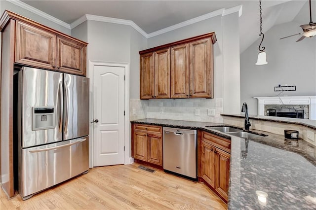 5195 Stefan Ridge Way, Buford, GA 30519 - kitchen with a sink, dark stone countertops, brown cabinets, light wood-type flooring, and appliances with stainless steel finishes