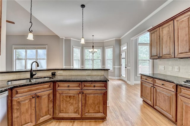 5195 Stefan Ridge Way, Buford, GA 30519 - kitchen featuring brown cabinetry, light wood-style flooring, a sink, and decorative light fixtures