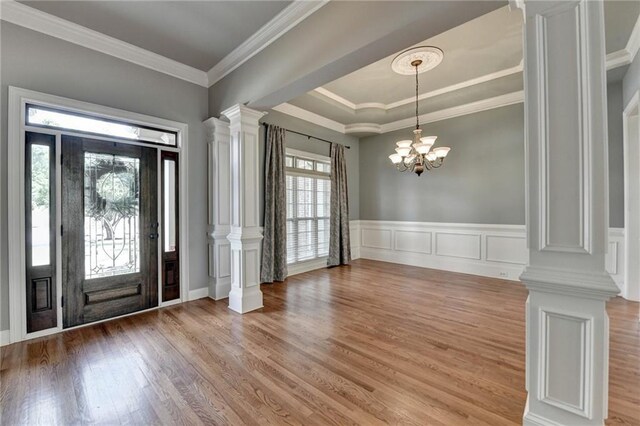 5195 Stefan Ridge Way, Buford, GA 30519 - entrance foyer featuring wood finished floors, decorative columns, crown molding, wainscoting, and a notable chandelier