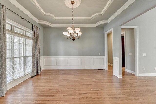5195 Stefan Ridge Way, Buford, GA 30519 - unfurnished dining area with light wood-style floors, a chandelier, a raised ceiling, and ornamental molding