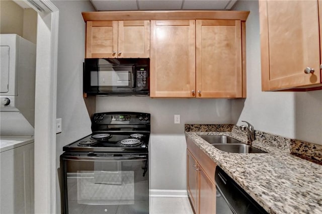 5195 Stefan Ridge Way, Buford, GA 30519 - kitchen featuring a sink, light stone counters, black appliances, light brown cabinetry, and stacked washing maching and dryer