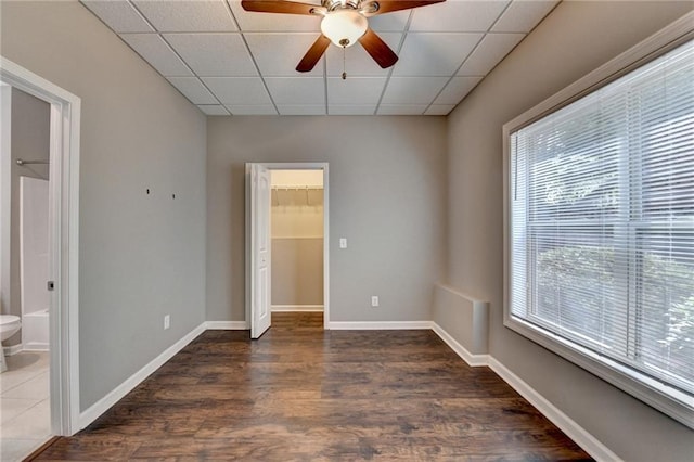 5195 Stefan Ridge Way, Buford, GA 30519 - unfurnished bedroom with a drop ceiling, a walk in closet, wood finished floors, and multiple windows