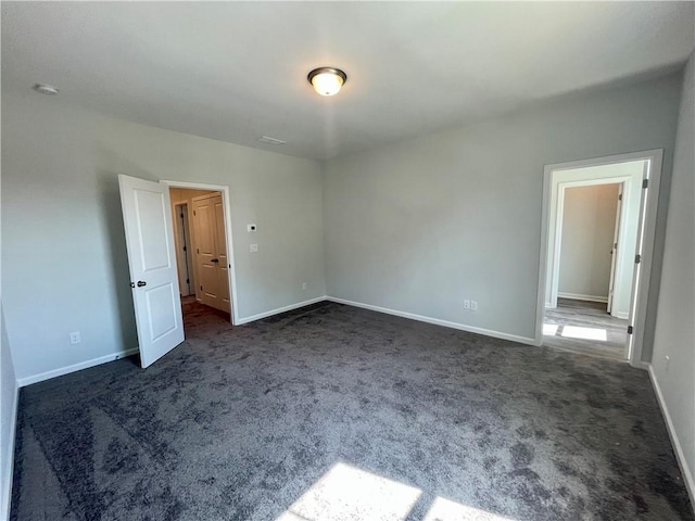 unfurnished room with dark carpet