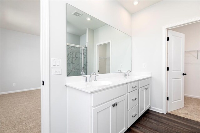 bathroom with hardwood / wood-style floors, vanity, an enclosed shower, and toilet