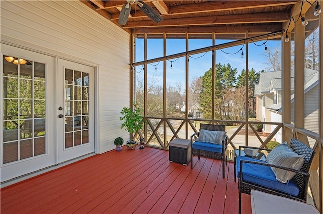 unfurnished sunroom featuring ceiling fan and beamed ceiling