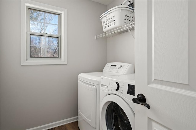 clothes washing area featuring laundry area, washing machine and dryer, and baseboards