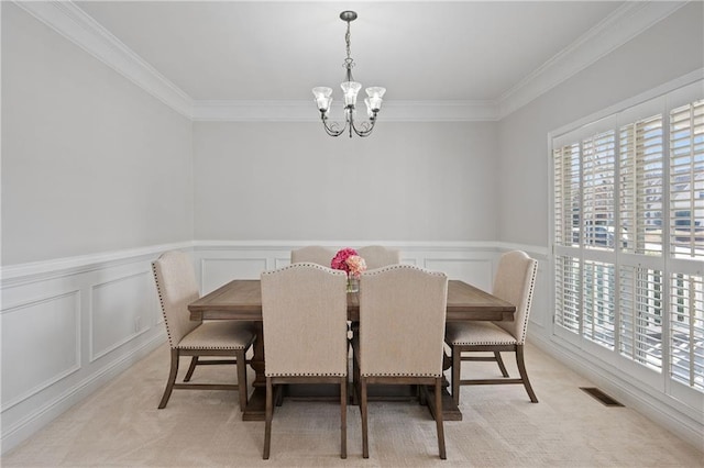 dining area with a notable chandelier, light colored carpet, a decorative wall, visible vents, and crown molding