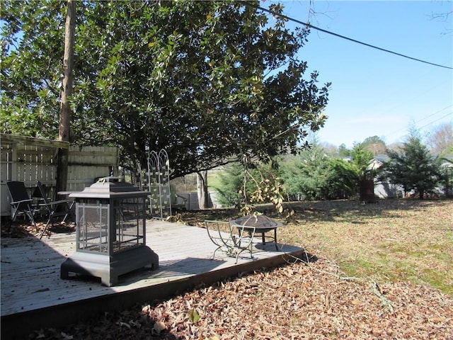 view of yard featuring a deck and an outdoor fire pit