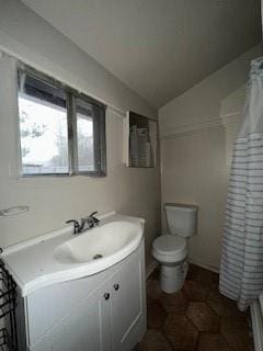 bathroom featuring vanity, vaulted ceiling, toilet, and walk in shower