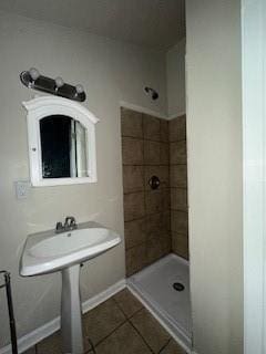 bathroom with a tile shower and tile patterned floors