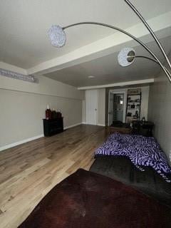 unfurnished living room with wood-type flooring and beam ceiling