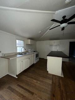 kitchen featuring sink, white cabinetry, vaulted ceiling, dark hardwood / wood-style flooring, and stove