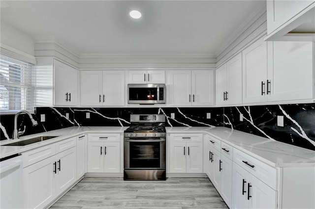 kitchen with white cabinets, sink, tasteful backsplash, light stone counters, and stainless steel appliances