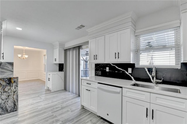 kitchen featuring white cabinetry, dishwasher, sink, hanging light fixtures, and light hardwood / wood-style flooring