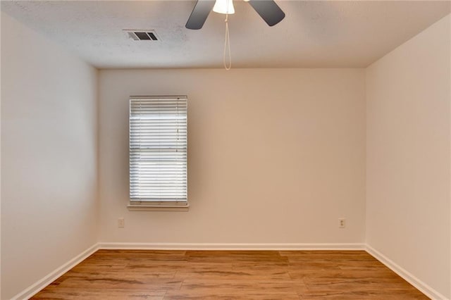 spare room featuring light hardwood / wood-style flooring and ceiling fan