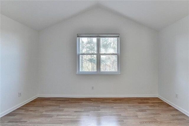 unfurnished room featuring light hardwood / wood-style floors and lofted ceiling