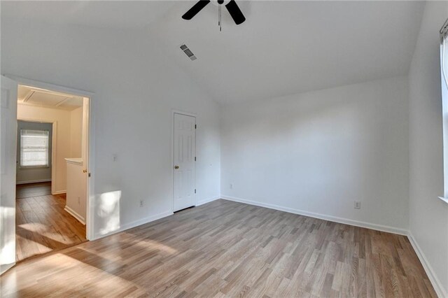 spare room featuring light wood-type flooring, high vaulted ceiling, and ceiling fan