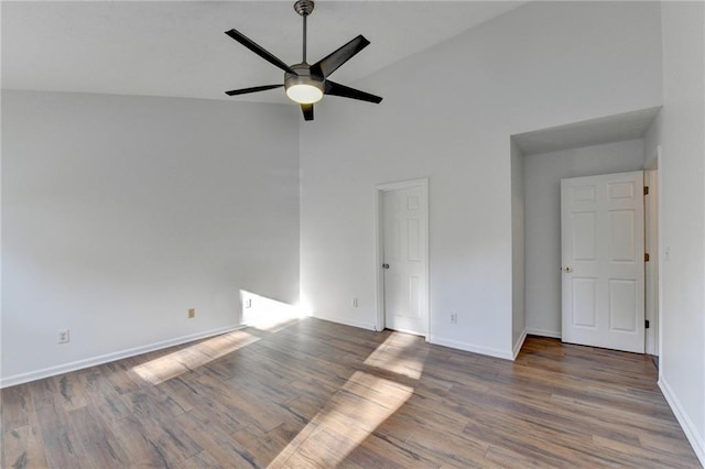 empty room featuring hardwood / wood-style flooring, ceiling fan, and high vaulted ceiling