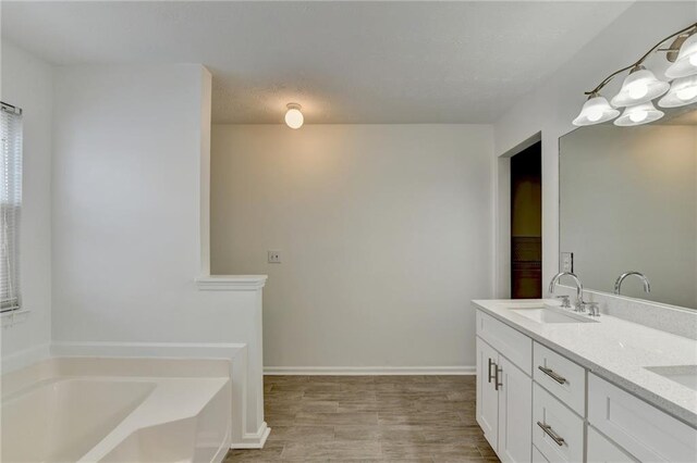 bathroom featuring vanity, a tub to relax in, and hardwood / wood-style flooring