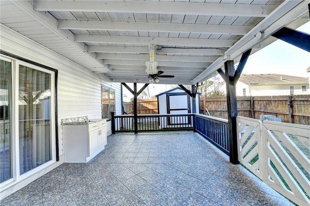 view of patio / terrace featuring ceiling fan and a storage shed