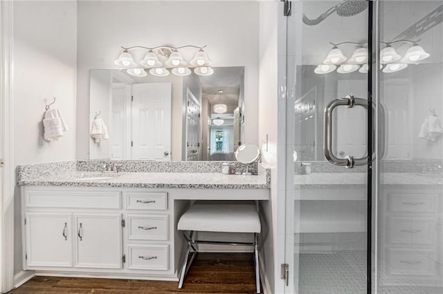 bathroom featuring a stall shower, vanity, and wood finished floors