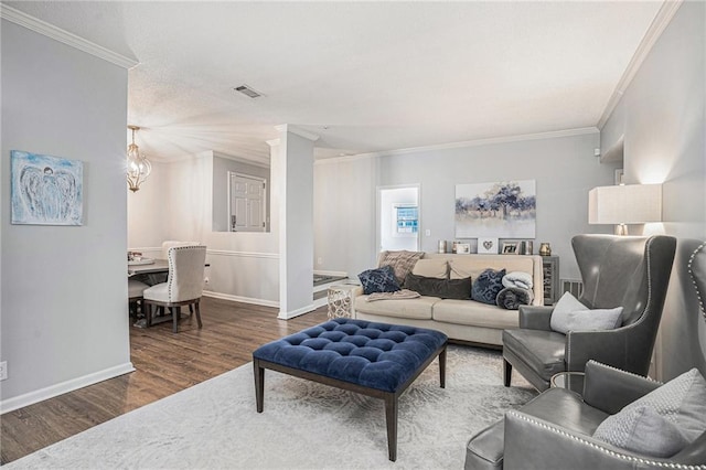 living area with wood finished floors, ornamental molding, and baseboards