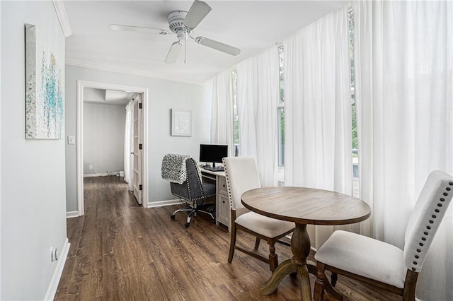 office area featuring plenty of natural light, dark wood-type flooring, baseboards, ornamental molding, and a ceiling fan