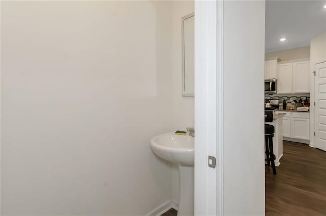 bathroom featuring backsplash, baseboards, recessed lighting, and wood finished floors