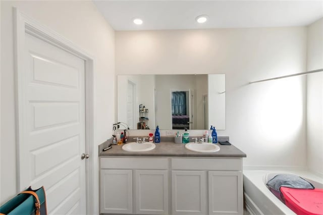full bathroom with a sink, double vanity, and a garden tub