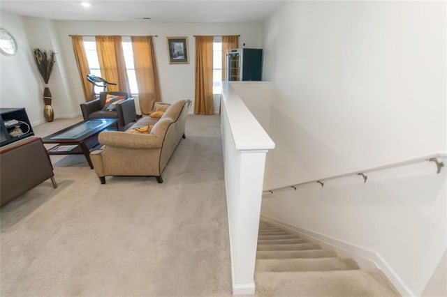 living area featuring light carpet and baseboards