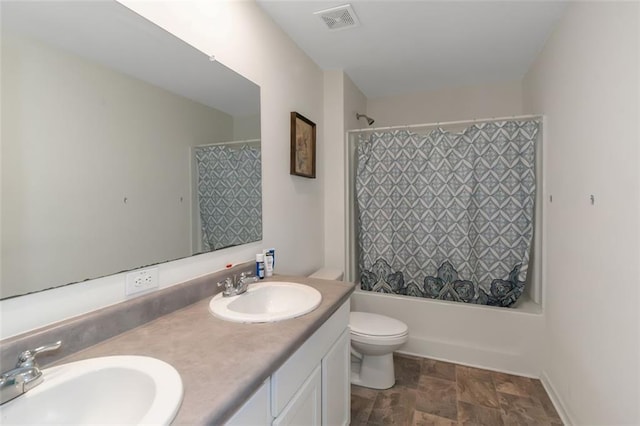 bathroom featuring a sink, visible vents, toilet, and stone finish floor