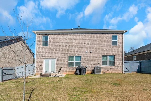 rear view of property with a yard, a fenced backyard, and brick siding