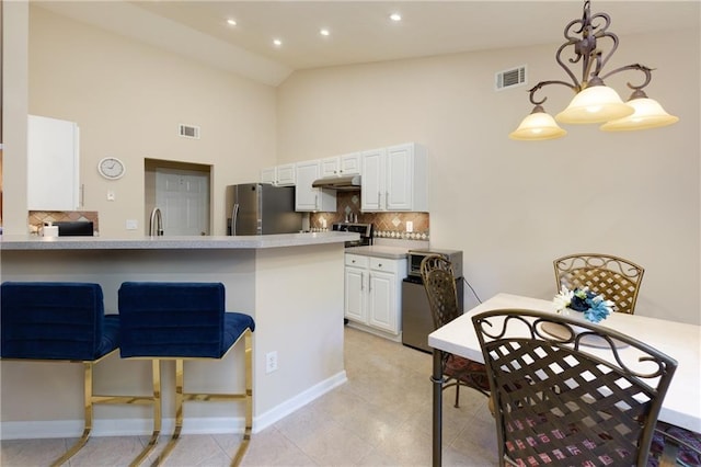 kitchen with white cabinets, stainless steel fridge with ice dispenser, visible vents, and under cabinet range hood