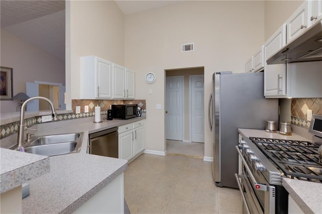 kitchen featuring visible vents, under cabinet range hood, appliances with stainless steel finishes, white cabinetry, and a sink