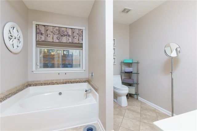 bathroom featuring tile patterned flooring, visible vents, baseboards, toilet, and a garden tub