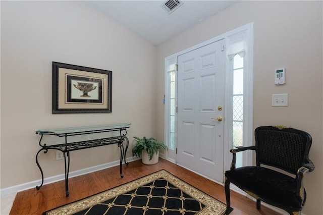 entrance foyer featuring visible vents, baseboards, and wood finished floors