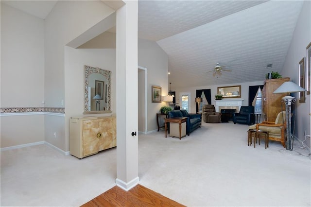 carpeted living room with lofted ceiling, a ceiling fan, a textured ceiling, baseboards, and a tile fireplace