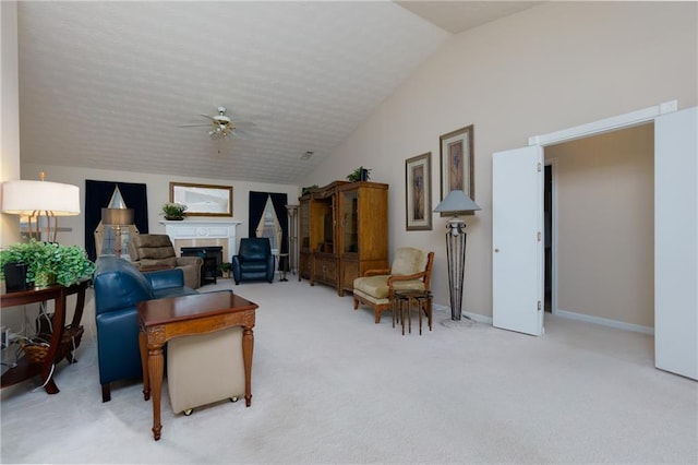 living area featuring ceiling fan, baseboards, carpet, lofted ceiling, and a fireplace