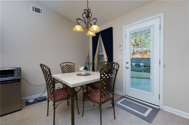 dining space featuring a toaster, visible vents, baseboards, and an inviting chandelier