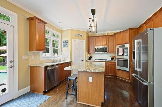 6317 Benbrooke Overlook NW, Acworth, GA 30101 - kitchen featuring stainless steel appliances, crown molding, a kitchen island, dark wood-type flooring, and tasteful backsplash