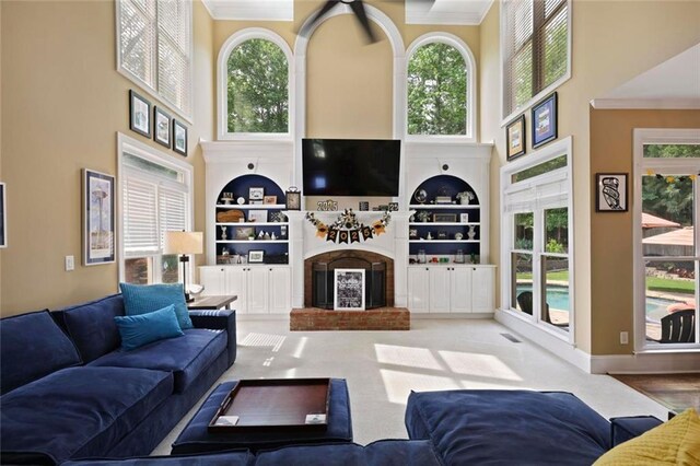 6317 Benbrooke Overlook NW, Acworth, GA 30101 - living area with a high ceiling, built in features, a brick fireplace, crown molding, and plenty of natural light