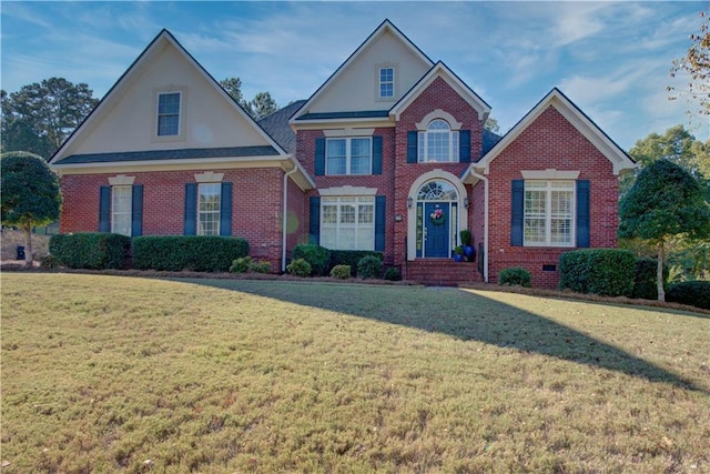 view of front of home with brick siding and a front lawn