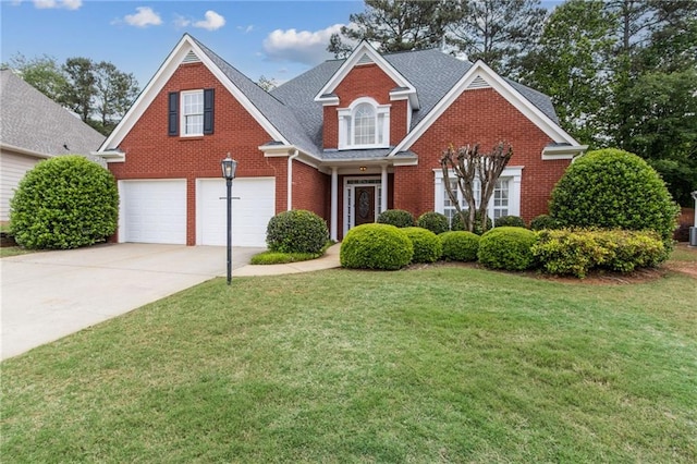 traditional-style house featuring concrete driveway, brick siding, an attached garage, and a front lawn
