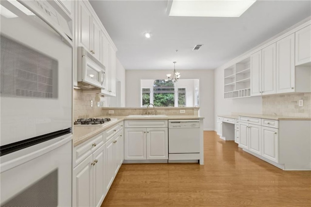 kitchen featuring white cabinets, open shelves, white appliances, a peninsula, and tasteful backsplash