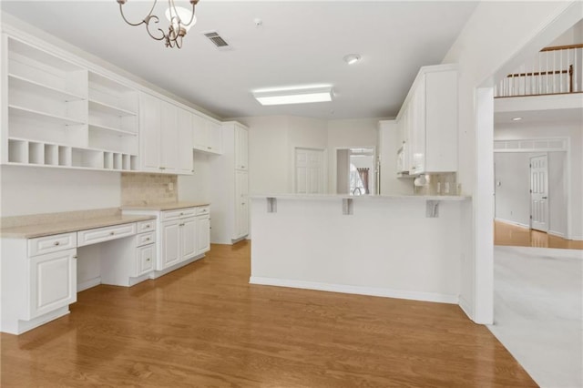 kitchen featuring visible vents, open shelves, a peninsula, light wood-type flooring, and white cabinets