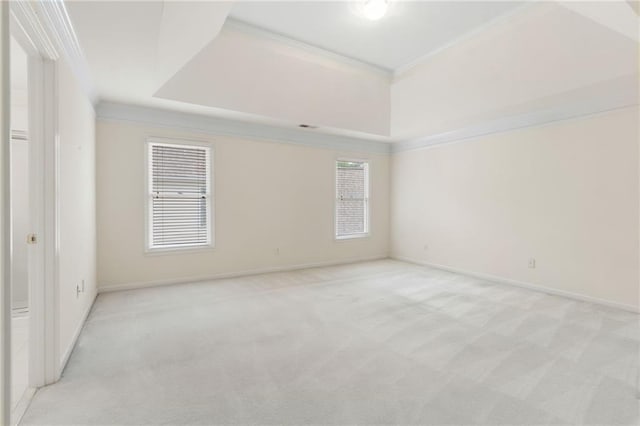 spare room with plenty of natural light, baseboards, ornamental molding, and light colored carpet