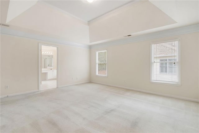 unfurnished room with visible vents, ornamental molding, baseboards, light colored carpet, and a tray ceiling