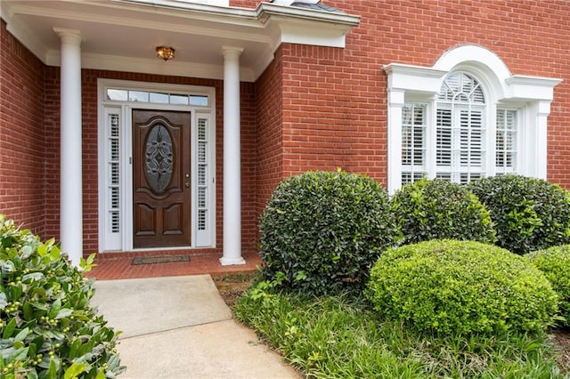 view of exterior entry featuring brick siding