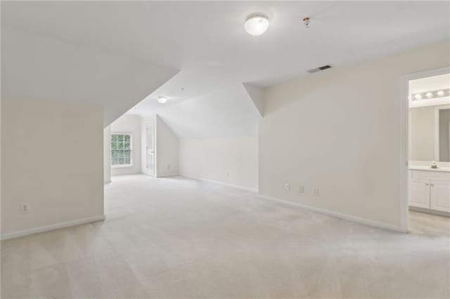bonus room with visible vents, baseboards, light colored carpet, and lofted ceiling